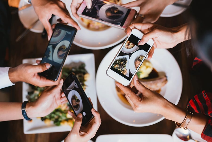 People taking photos of their meals at restaurants