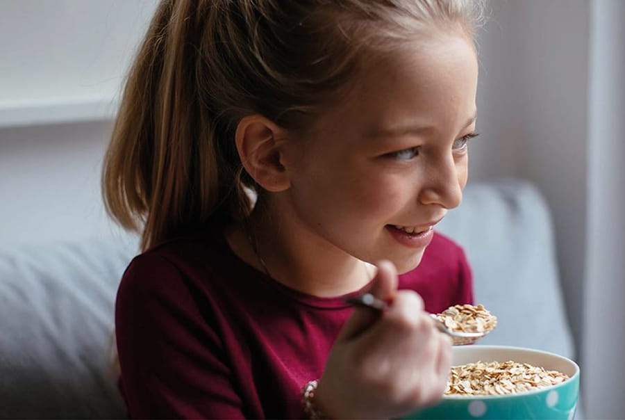 Child eat cereal with milk