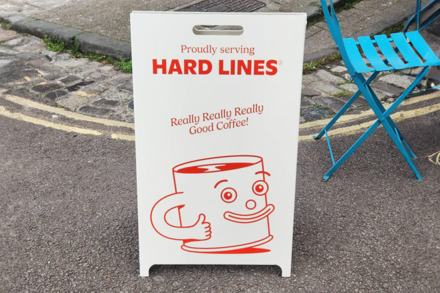 Hard Lines Coffee A Stand outside of cafe, in street.