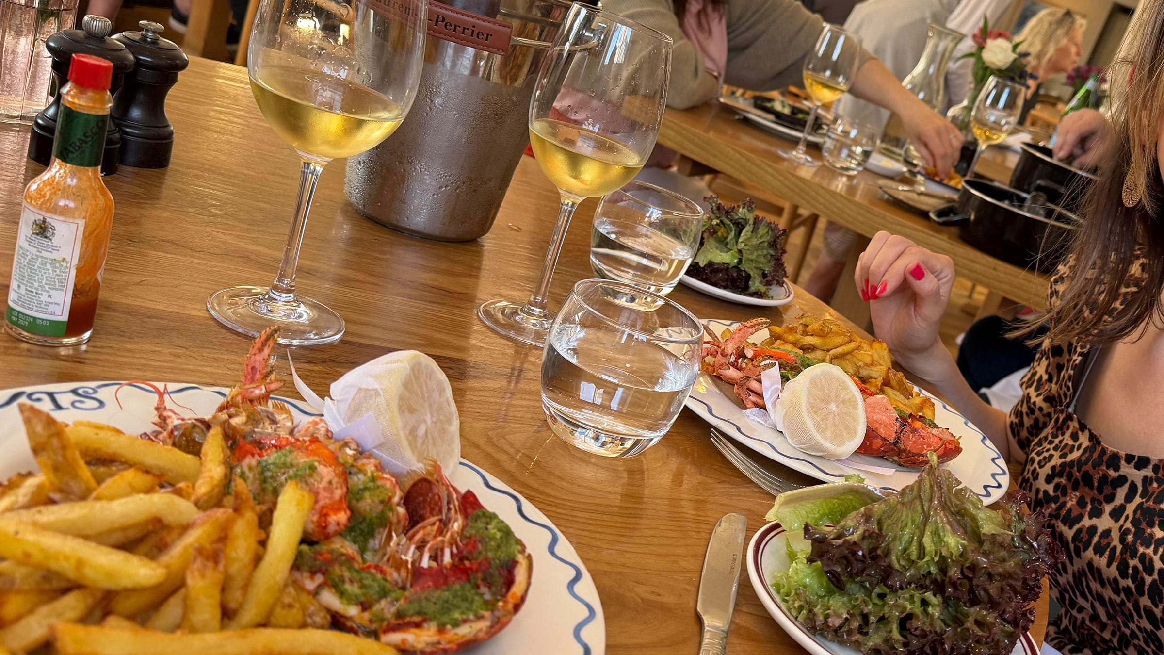 Lobster and chips with white wine at restaurant table